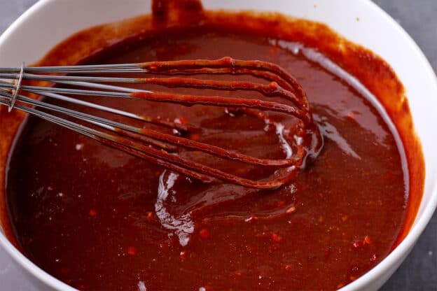 A sauce is stirred with a whisk.