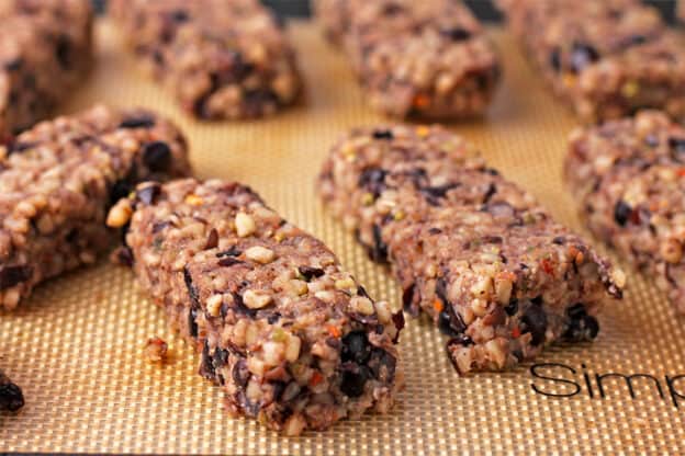 Vegan koftas with black beans are ready to bake on a baking mat.