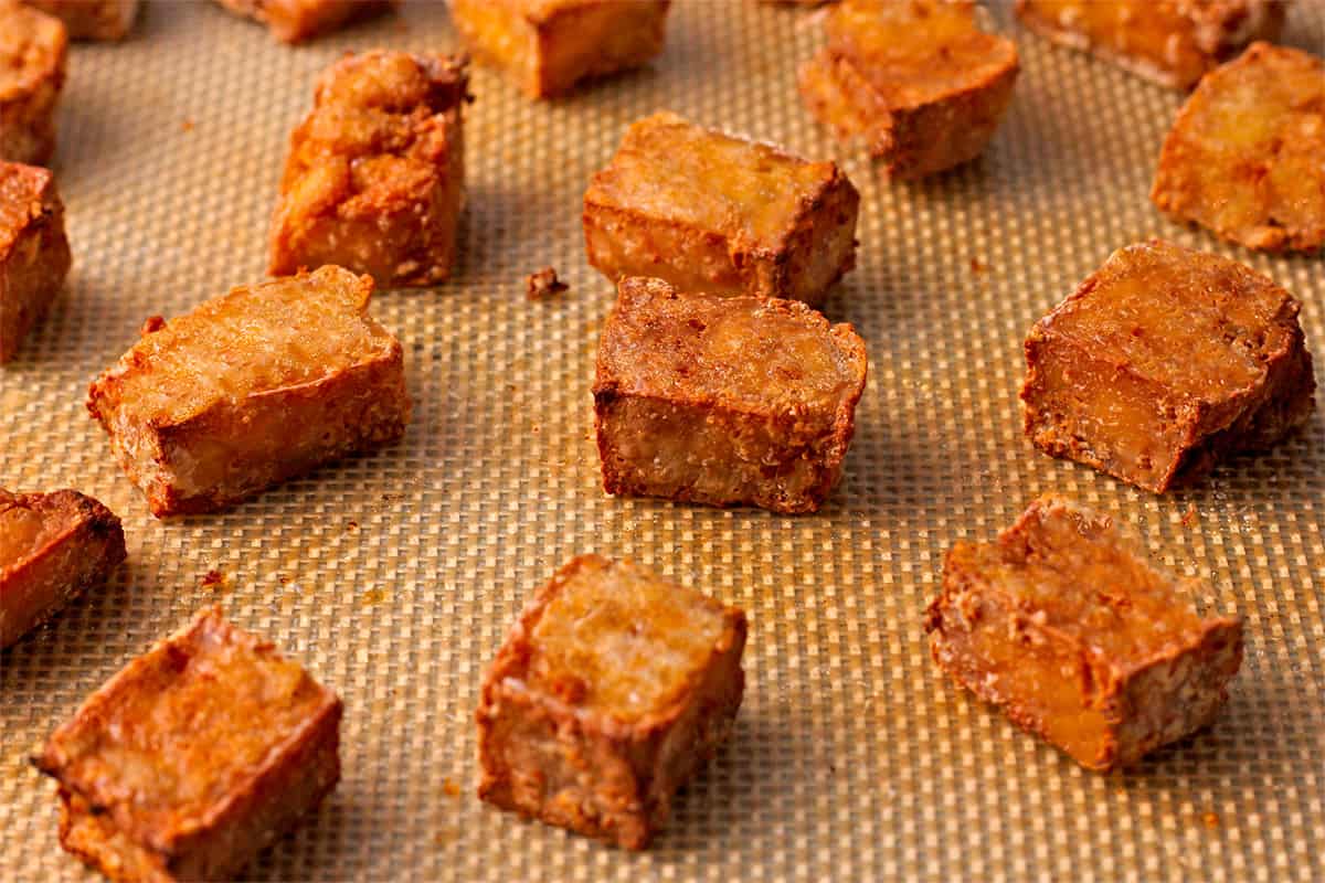 Crispy baked tofu cubes on silicon mat. 
