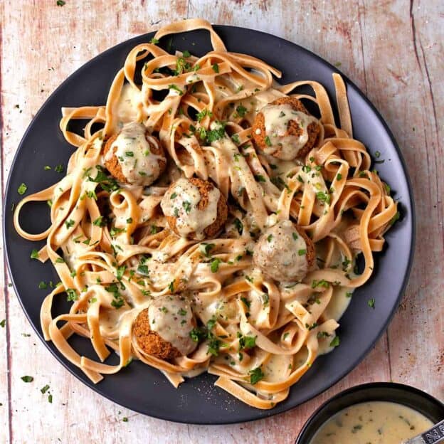 vegan Swedish meatballs and gravy with pasta on a plate.