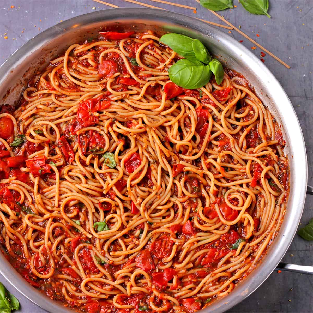 A skillet filled with cooked spaghetti and red sauce.