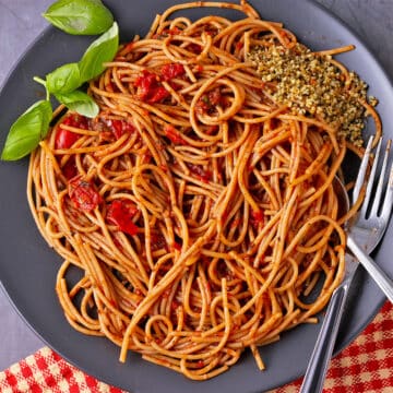 A plate of spicy spaghetti arrabbiata with basil.