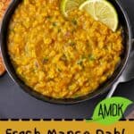 Mango red lentil dahl in a bowl with lime wedges.