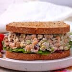 A sandwich with cranberry walnut chickpea salad and lettuce.