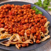 A plate of chickpeas in tomato sauce with pasta.