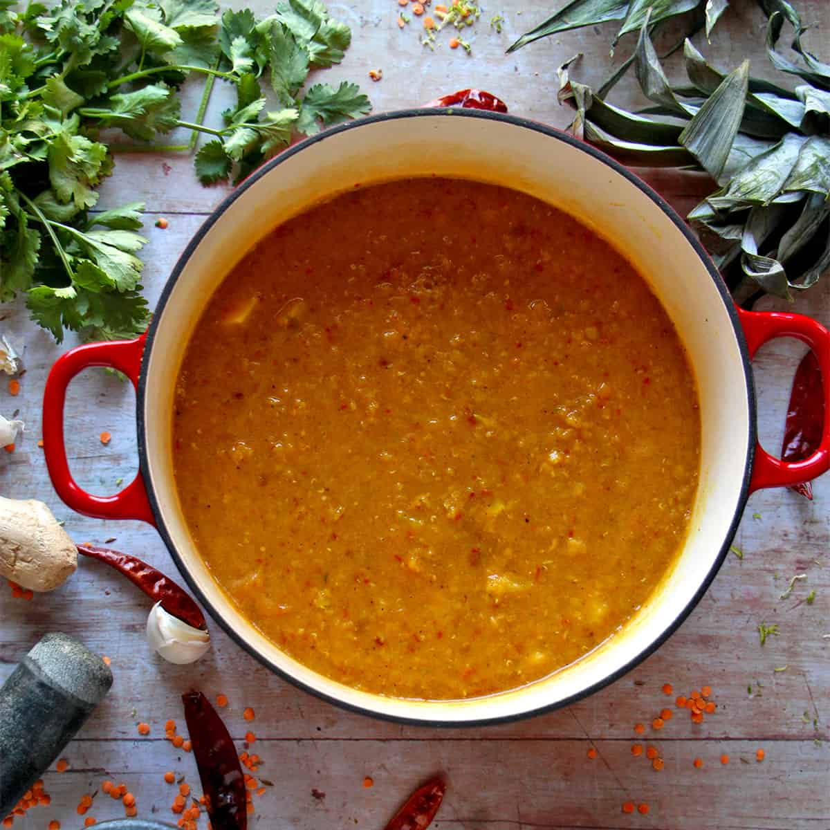 A soup pot filled with red lentil soup.