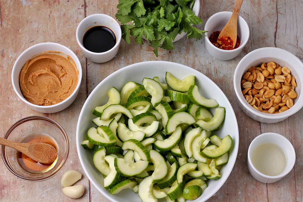 Sliced cucumbers, garlic, maple syrup, peanut butter, soy sauce, cilantro, red chili flakes, peanuts, and rice vinegar.