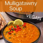 A bowl of mulligatawny soup with chilies and cilantro.