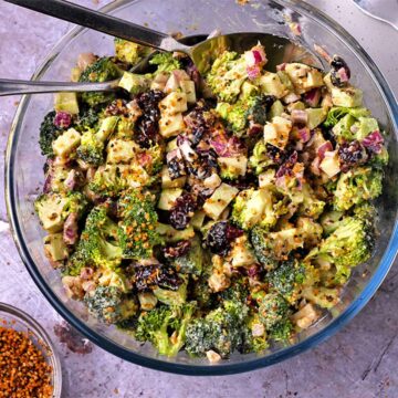 Overhead of broccoli salad with vegan bacon bits, cranberries, and dressing.