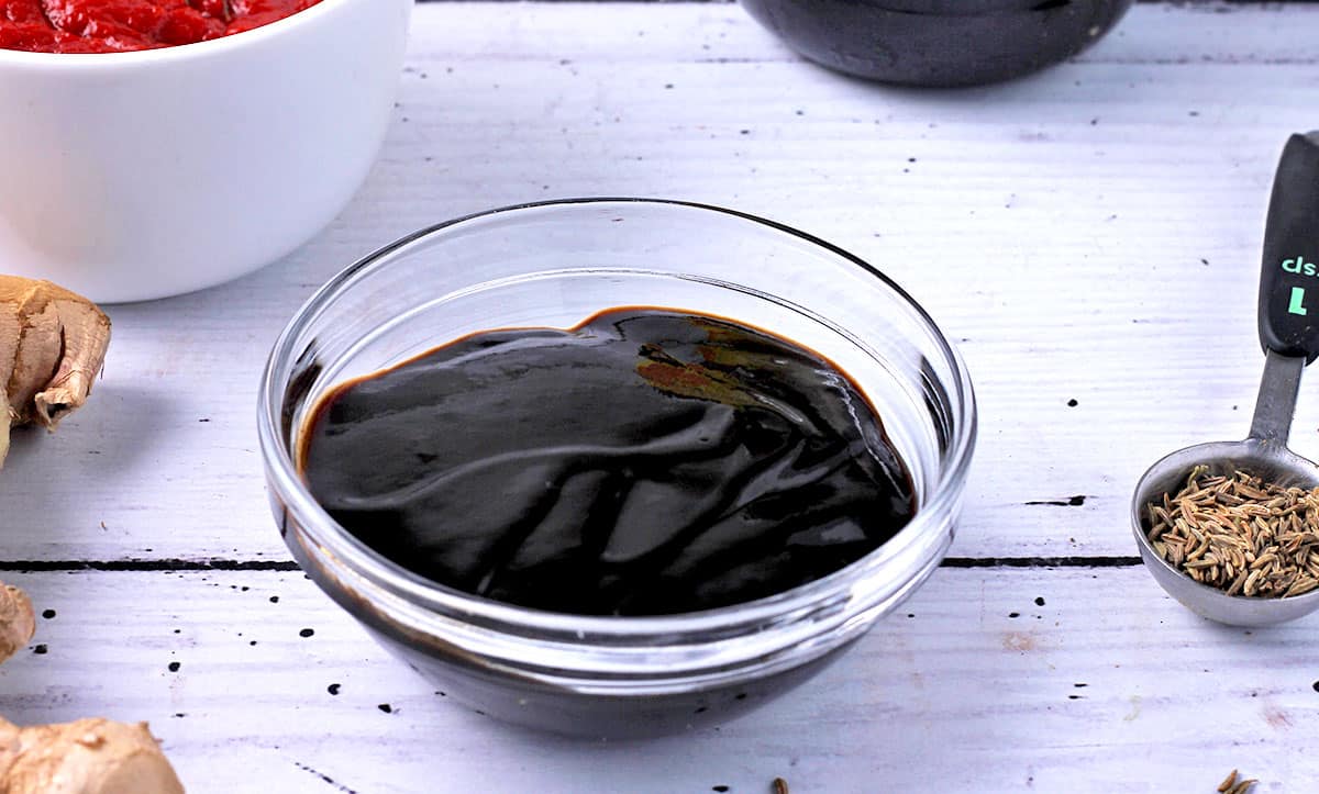 A small glass bowl filled with tamarind paste.