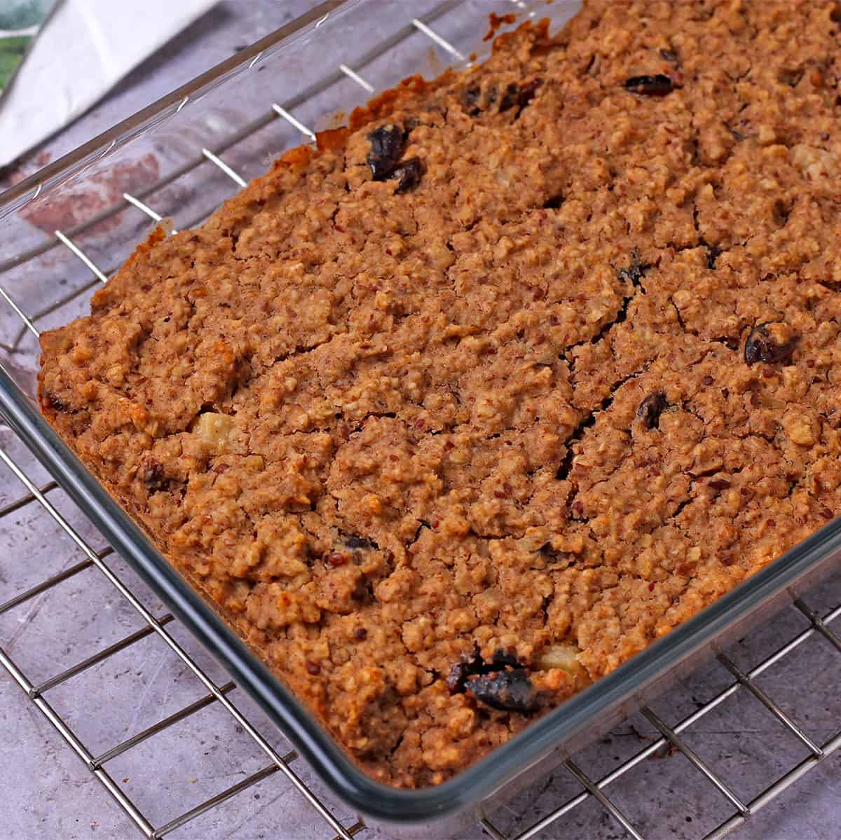 Baked oatmeal in a glass baking dish on a wire rack.
