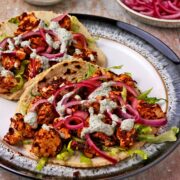 2 barbacoa cauliflower tacos with lettuce, pickled red onions, and pepita dressing.