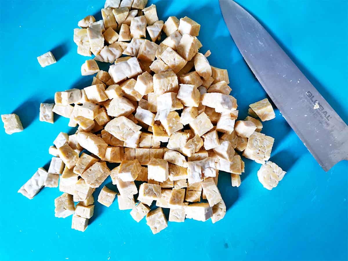 Tempeh cubes are piles on a blue mat.