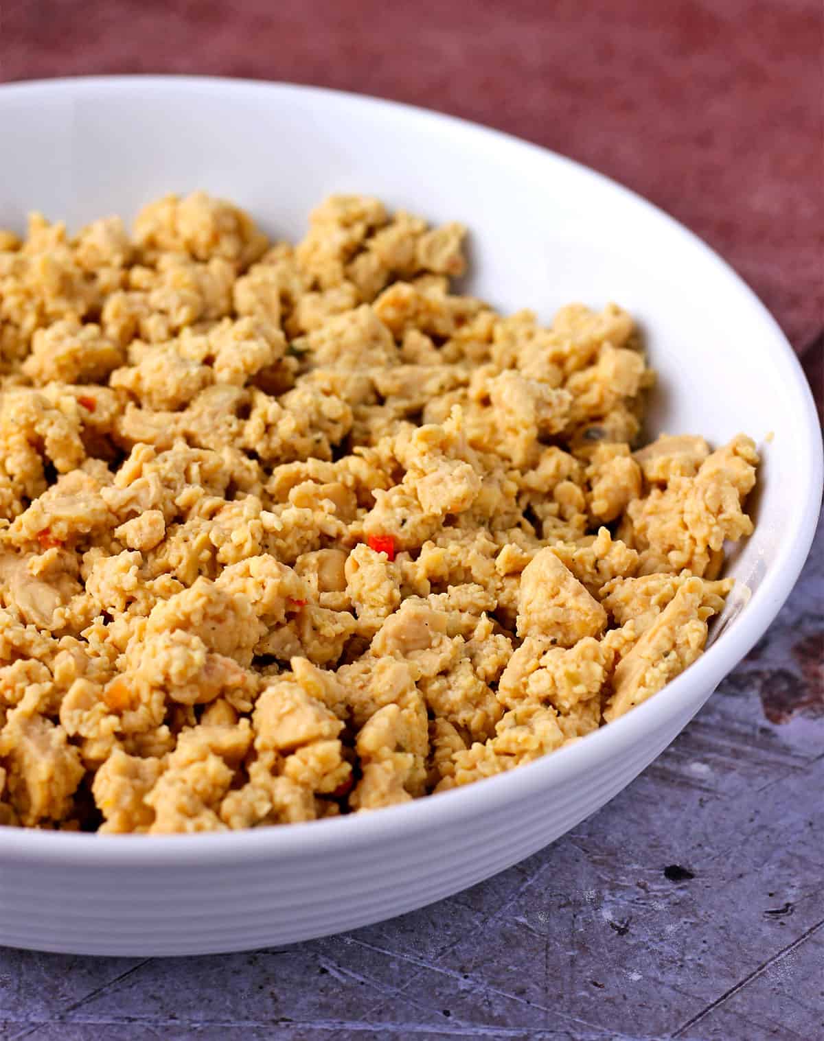 Simmered tempeh crumbles in a white bowl.