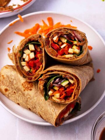 White bean wraps with veggies are cut and placed on a plate.