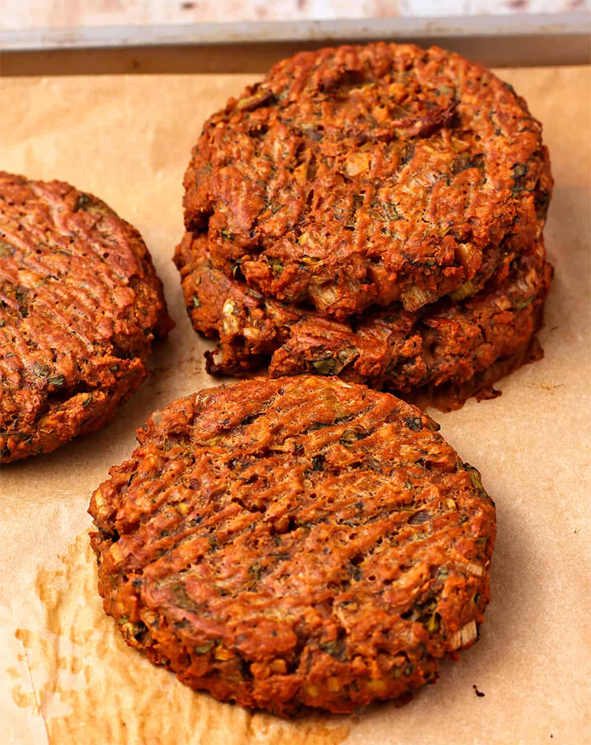 Baked tofu burger patties on parchment paper.