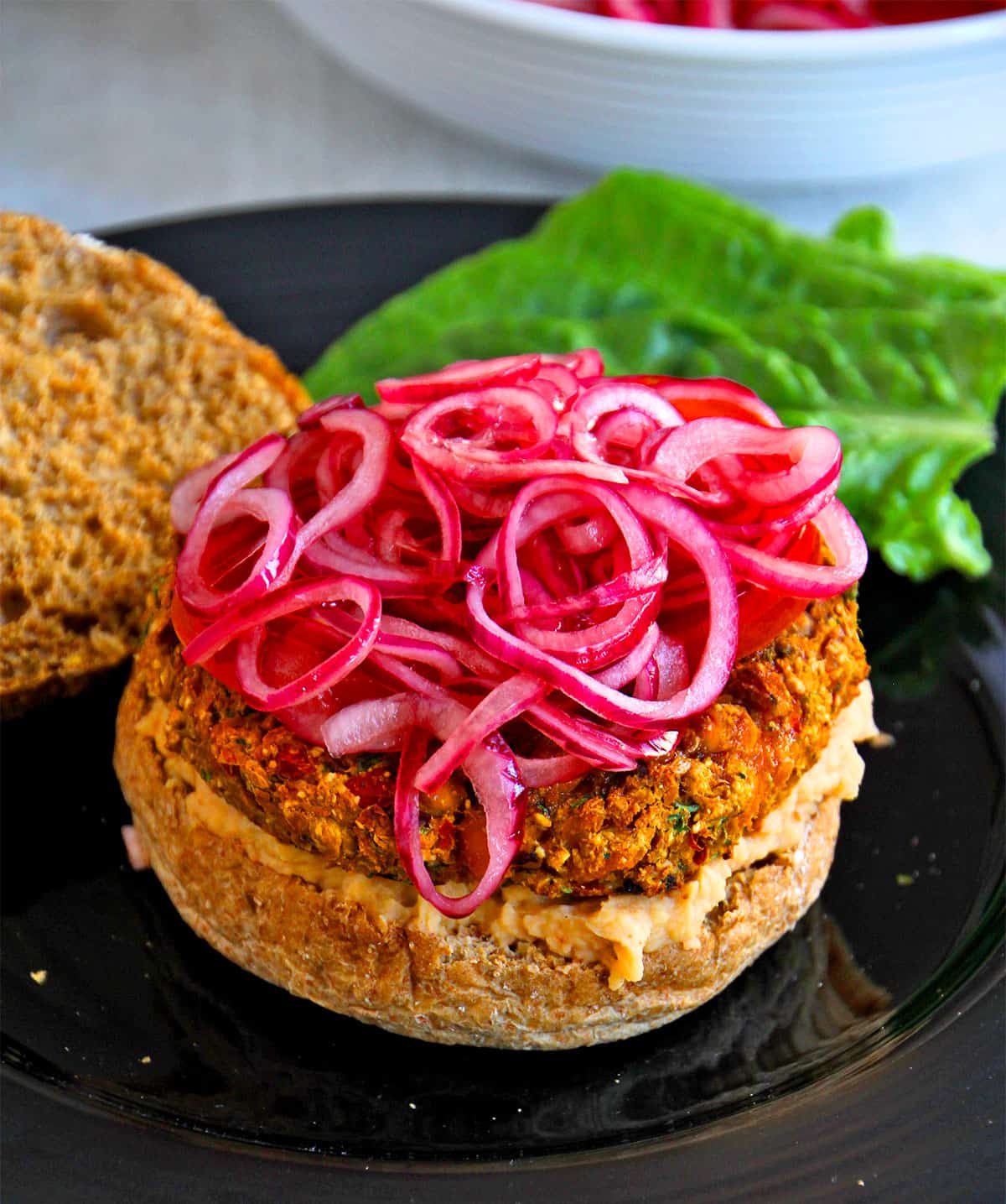 Quick pickled red onions on top of a veggie burger.