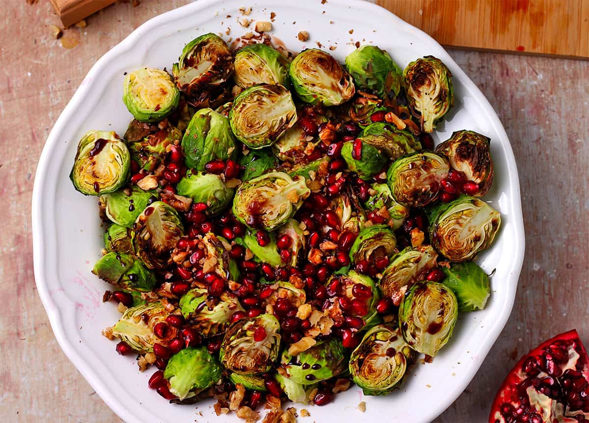 Overhead of air fryer brussels sprouts with pomegranate and walnuts.