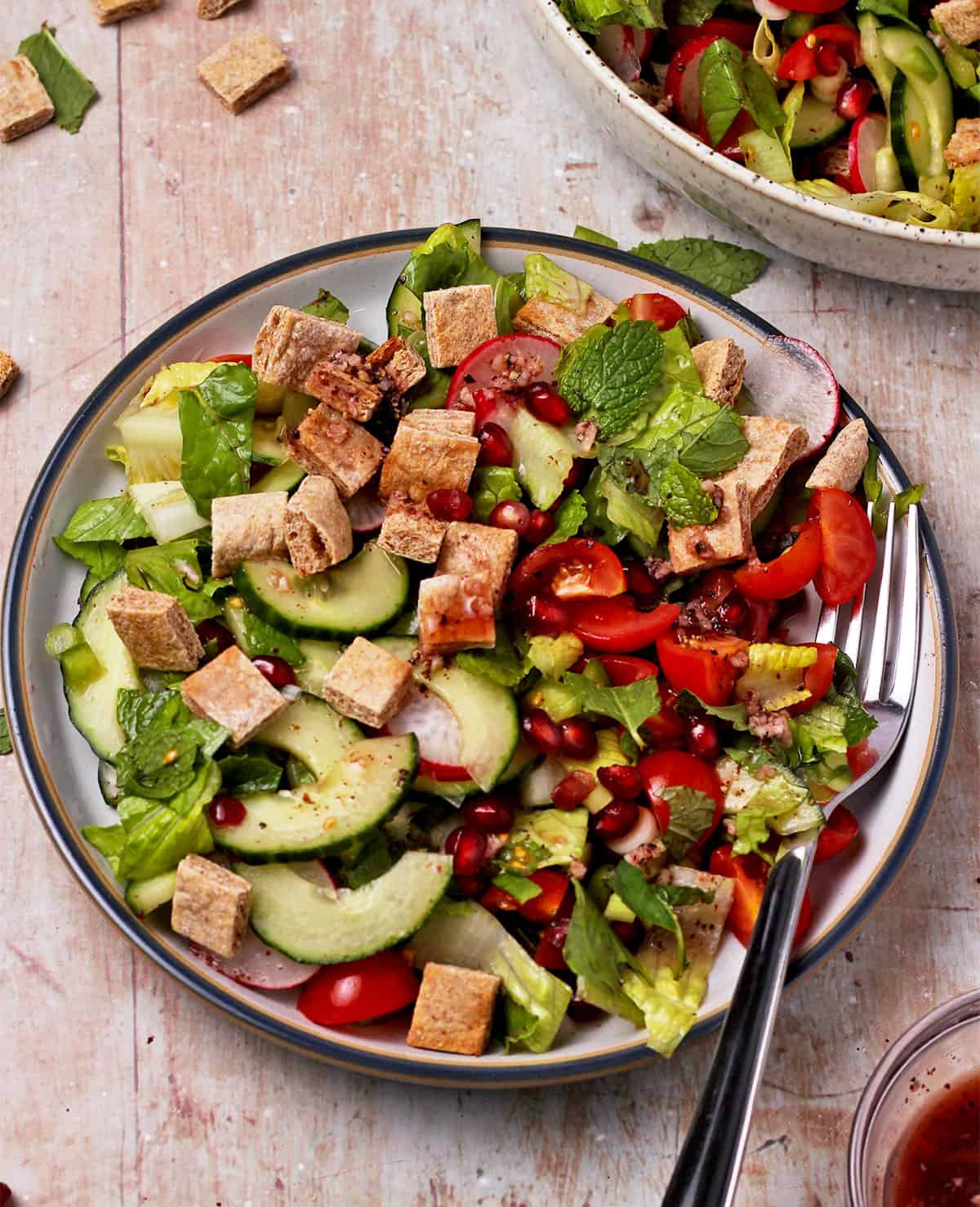 Fattoush salad on a plate with a fork.
