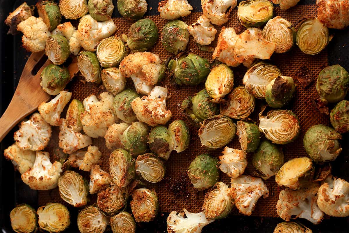 Roasted brussels sprouts and cauliflower on a baking tray.