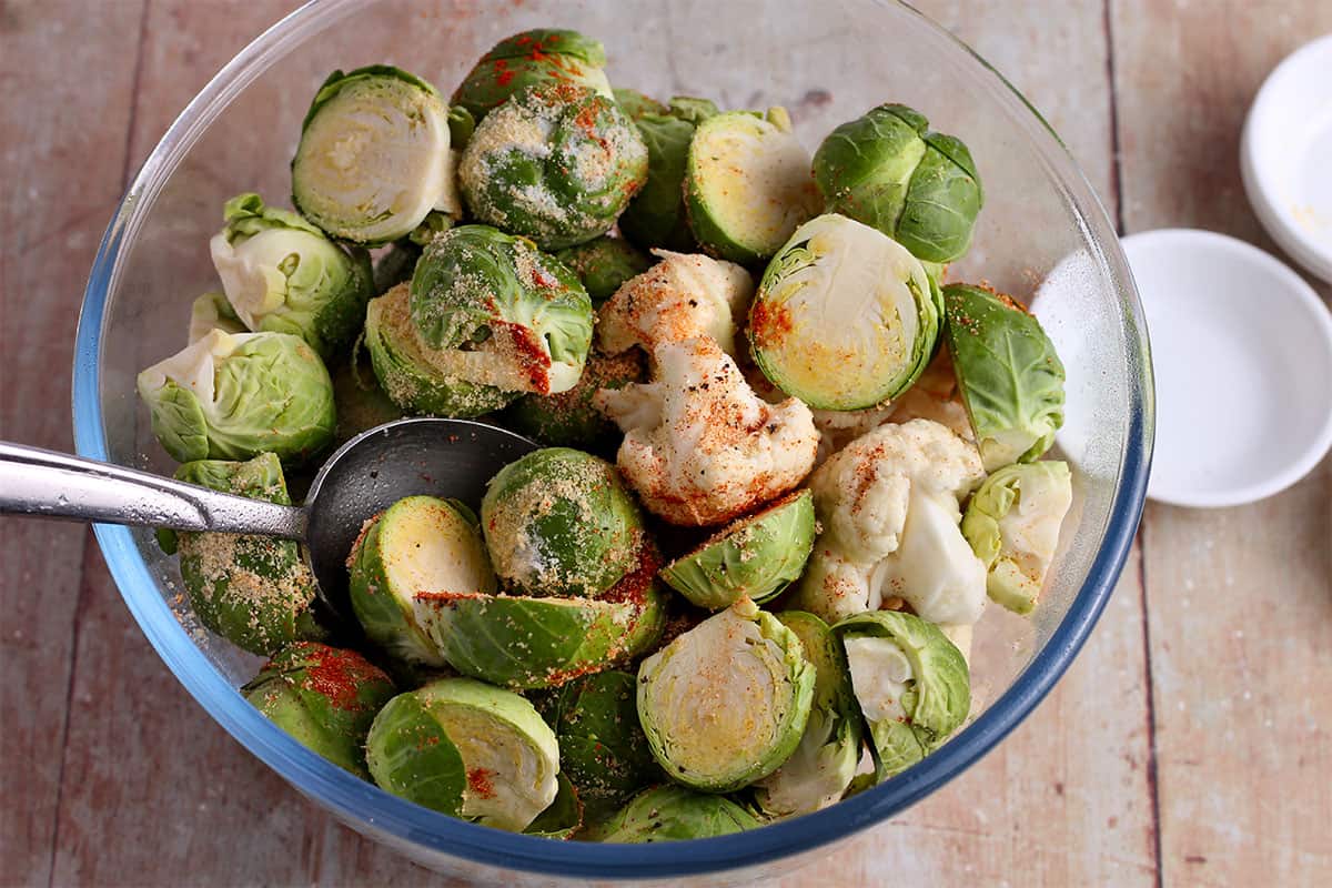 Cut brussels sprouts and cauliflower florets are tossed with spices.