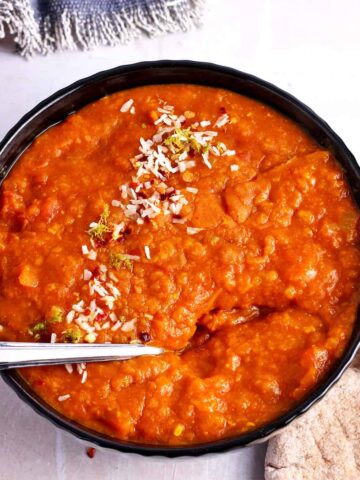 A bowl of masoor dal with a spoon.