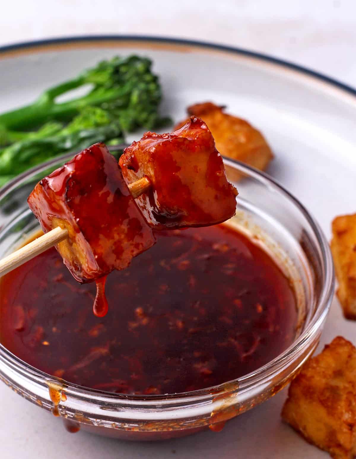 Tofu cubes dipped in sriracha sauce.