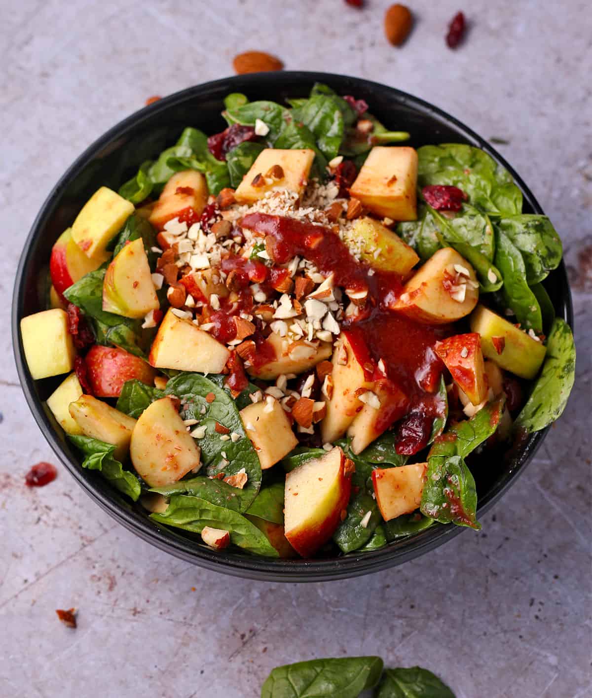 Apple cranberry spinach salad with dressing.