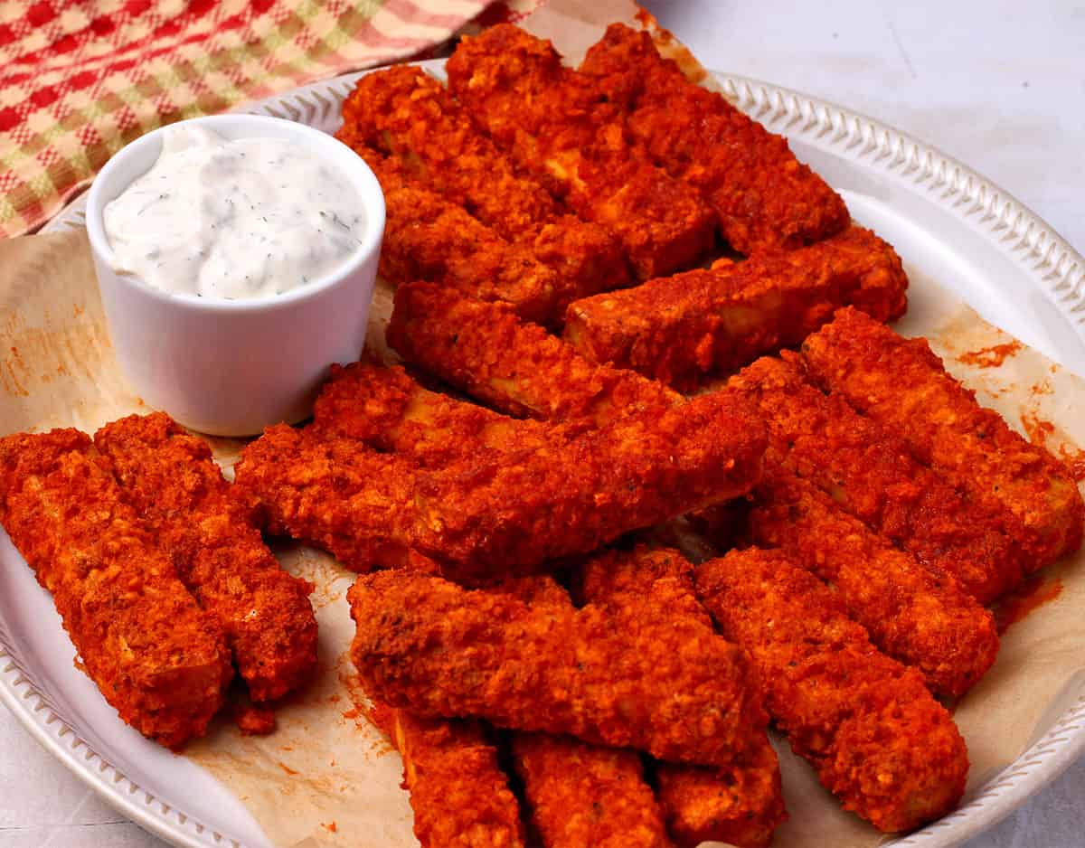 A plate of buffalo tofu strips with ranch dressing in a small bowl.