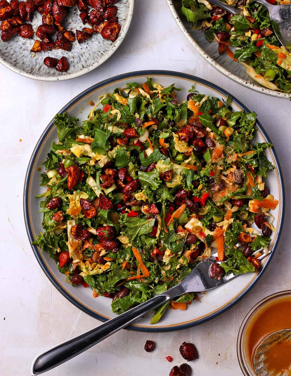 Asian kale salad with almonds and Adzuki beans on a plate with a fork.