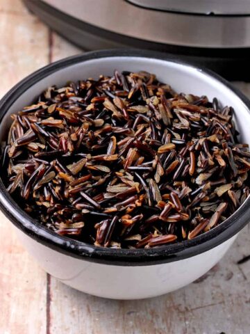 Cooked wild rice in a white bowl.