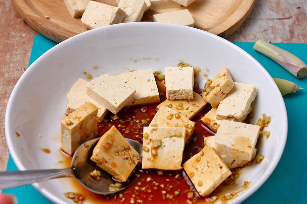 Tofu cubes are mixed with lemongrass marinade.