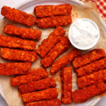 Strips of Buffalo tofu on a plate with a small dish of ranch dressing.