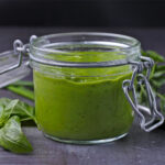 A mason jar is filled with avocado green goddess dressing.