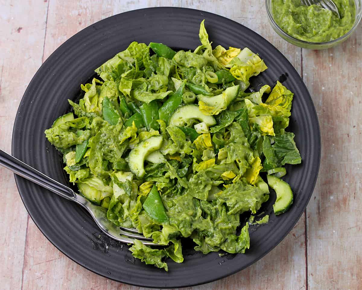 A green salad with cucumbers and avocado green goddess dressing.