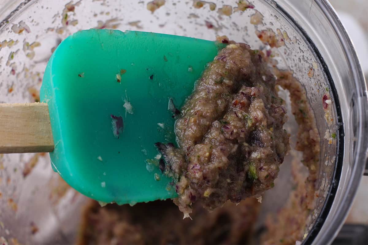 Curry paste in a blender on a green spatula.