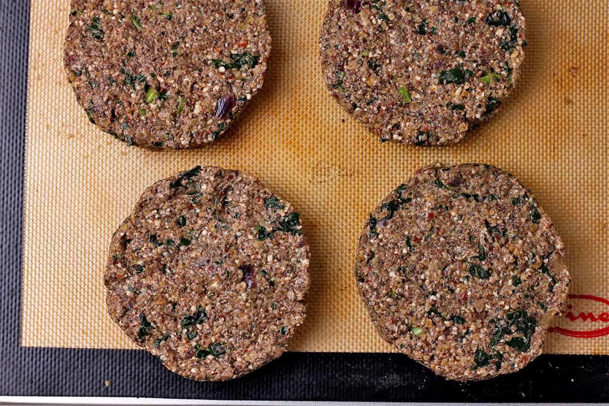 Mushroom kale burger patties on a baking mat.