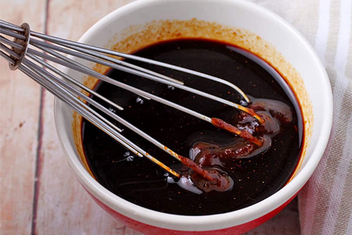 Hoisin sauce is whisked into soy sauce in a small bowl.
