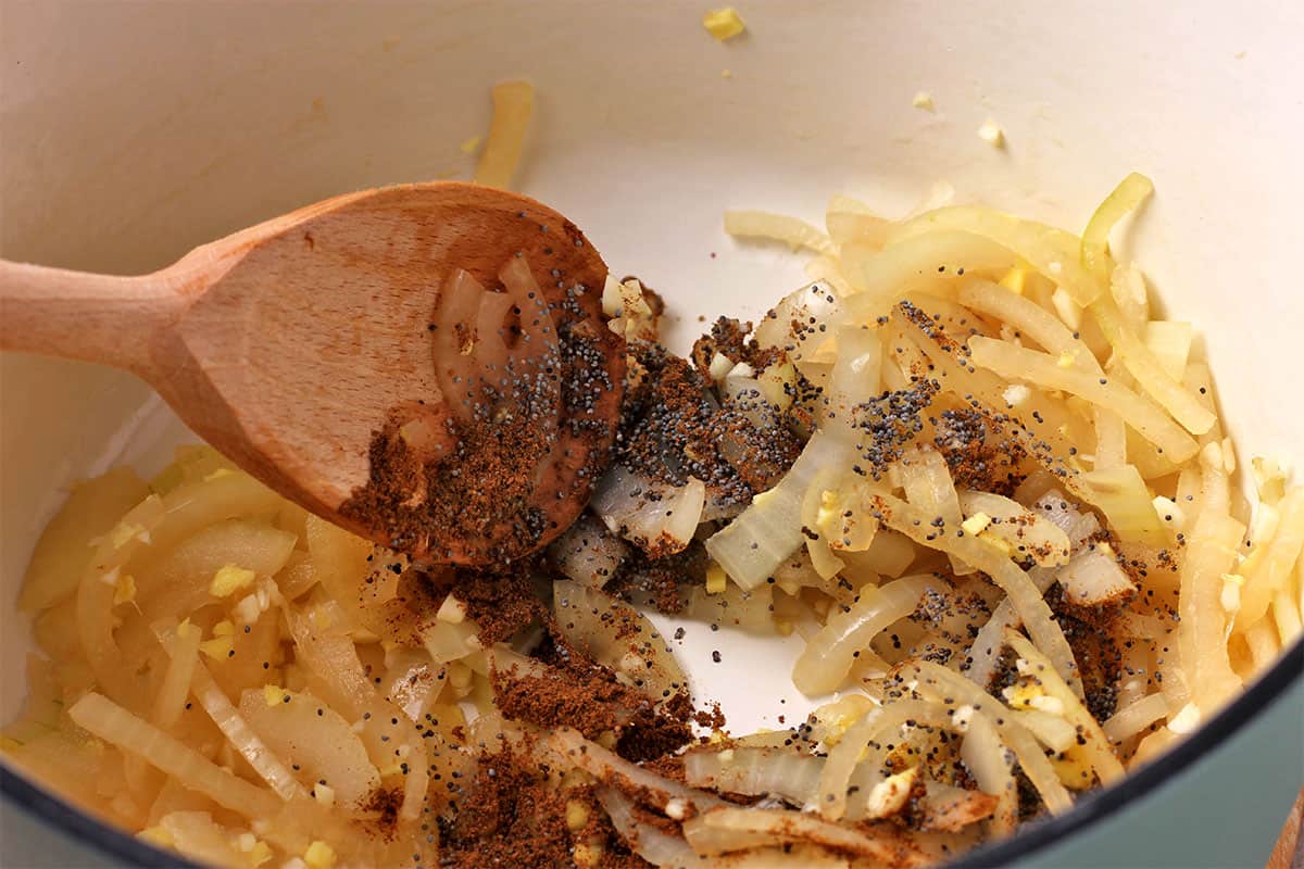 Spices are stirred into cooked onions.