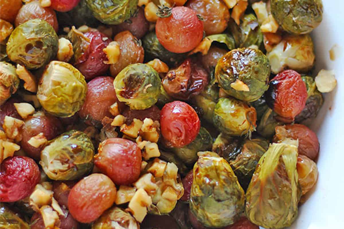Roasted Brussels sprouts, red grapes, and walnuts with Balsamic vinegar in a bowl.
