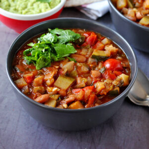 Zucchini chili with tomatoes and pinto beans in a bowl.