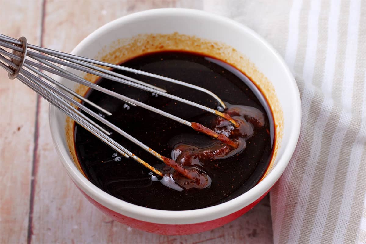 Hoisin sauce is whisked in a bowl. 
