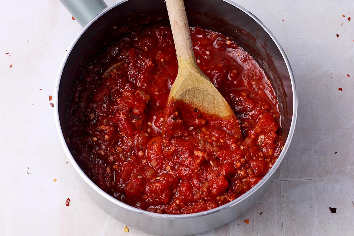 Marinara dipping sauce simmered in a saucepan.