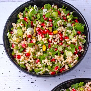 Pearl couscous salad with pomegranate, herbs, green onions, and pistachios.