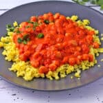 Chickpeas romesco over rice on a plate.