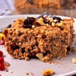 A slice of vegan baked oatmeal with cranberries and walnuts.
