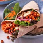 BBQ chickpea wraps with lettuce, dressing, and vegetables.