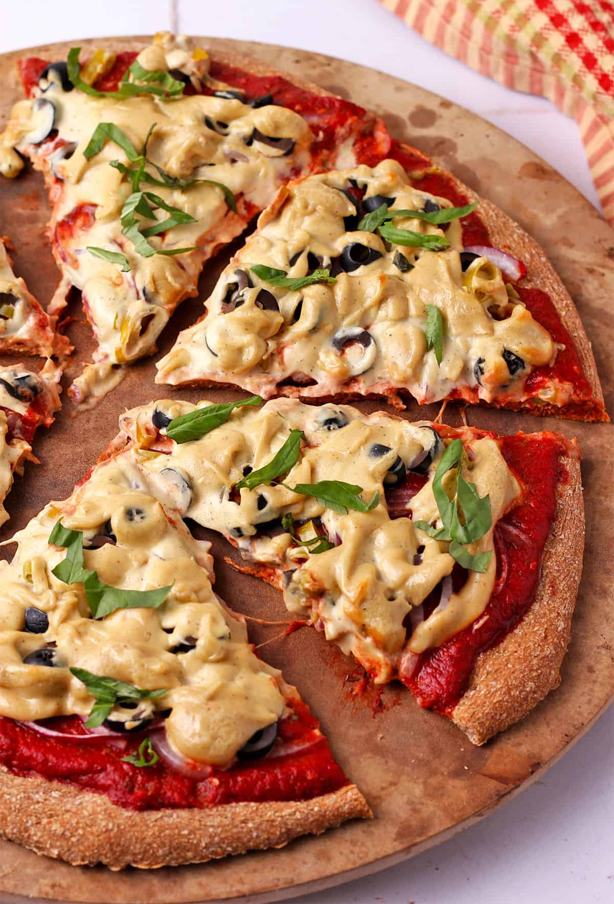 A sliced pizza with vegan pizza cheese.