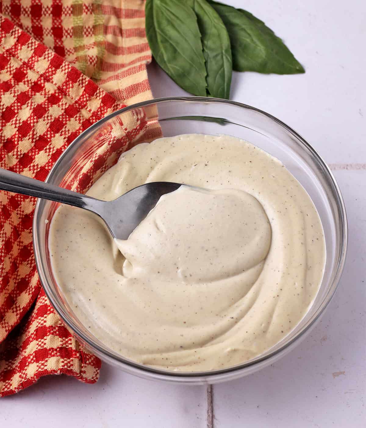Vegan pizza cheese in bowl with spoon.