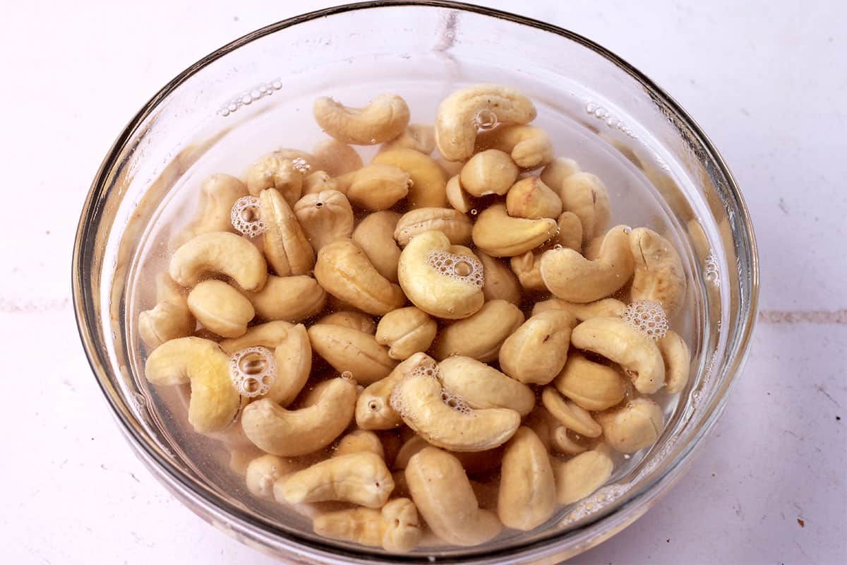 Cashews soak in a bowl with water.